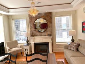 a living room with a fireplace and a mirror at Water Street and HarborGate Condos & Studios in St. John's