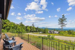 a balcony with chairs and a table and a fence at Trapp Hill View in Stowe