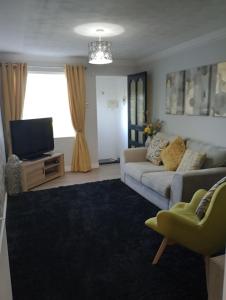 a living room with a couch and a tv at Station Retreat in Boldon