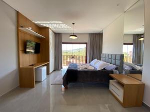 a bedroom with a bed and a desk and a television at Serra dos encantos in Lavras Novas