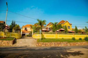 a group of houses with yellow walls and a street at DANA KIGALI HOTEL in Kigali