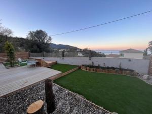 un piccolo cortile con terrazza in legno e prato di Casa Di Legnu a Bastia