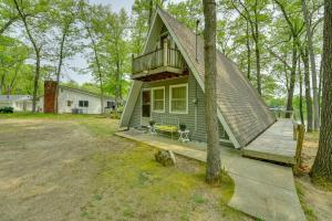 a small green house with a porch and a deck at Long Lake Cabin with Kayaks, Private Beach and Dock! in Fountain