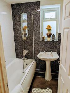 y baño con lavamanos, bañera y lavamanos. en Stylish & Comfortable House in Swansea, en Morriston