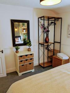 1 dormitorio con cama, espejo y tocador en Stylish & Comfortable House in Swansea, en Morriston