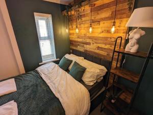 1 dormitorio con 1 cama y pared de madera en Stylish & Comfortable House in Swansea, en Morriston