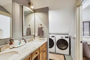 a laundry room with two sinks and a washer and dryer at TrappHof in Stowe