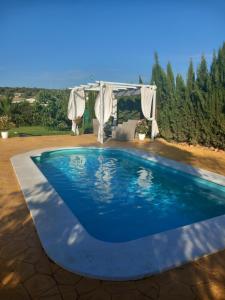 a swimming pool in a backyard with a gazebo at Casa Villa El Olivar in Huelva