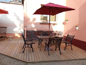 a patio with a table and chairs and an umbrella at Storchennest mit großem Garten für Urlaubsgäste in Nauen