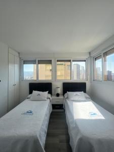 deux lits assis dans une pièce avec fenêtres dans l'établissement El Apartamento de Cristian, à Benidorm