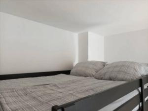 a bed in a bedroom with a white wall at Helles Apartment am Elberadweg in Magdeburg
