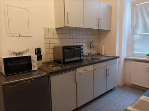 y cocina con microondas y fregadero. en Helles Apartment am Elberadweg, en Magdeburgo