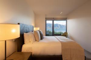a bedroom with a bed and a large window at Aspen Grove in Queenstown