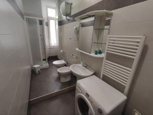 ein Badezimmer mit einem Waschbecken, einem WC und einem Spiegel in der Unterkunft Coccole Apartment in La Spezia