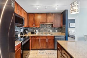 a kitchen with wooden cabinets and a sink at Laketown Wharf #1509 by Nautical Properties in Panama City Beach