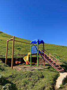 a playground with a slide in a field at Karester Villa Apart in Uzungöl