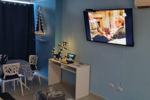 uma sala de estar com uma televisão pendurada numa parede em Hermoso apartamento de Playa en Coronado em Playa Coronado