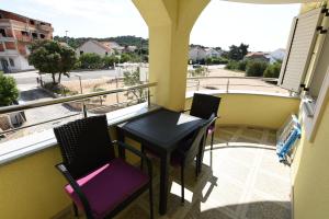 einen Balkon mit einem Tisch und Stühlen sowie Straßenblick in der Unterkunft Apartments Mario in Brodarica