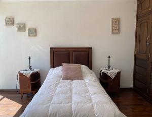 een slaapkamer met een bed met 2 nachtkastjes en 2 tafels bij Dpto. Cómodo, Soleado Dpto Z. Sur, Teleférico ONU in La Paz