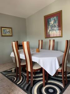 a dining room table and chairs with a white table cloth at Derick's Inn in Piarco