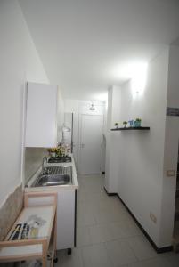 a white kitchen with a sink and a refrigerator at Casa Cinisi - Casa Vacanze in Cinisi