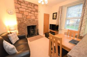 uma sala de estar com um sofá, uma mesa e uma lareira em Snug on the Tweed em Berwick-Upon-Tweed