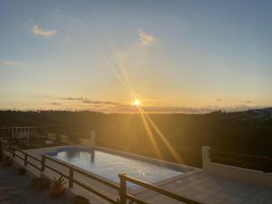 uma piscina no telhado de uma casa com o pôr do sol em Terra Luso Proche De Montejunto em Cadaval