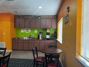 a kitchen with a table and chairs in a room at Super 8 by Wyndham Houston/Brookhollow NW in Houston