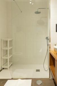 um chuveiro com uma porta de vidro na casa de banho em Jack&Lily's em Évora