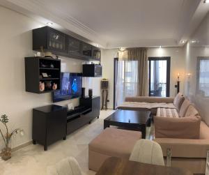 uma sala de estar com um sofá e uma televisão em Appartment Jnane Atlas em Marrakech