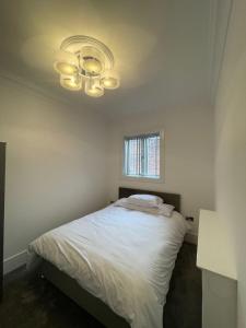 a bedroom with a white bed and a window at Luxury Apartment APT5 in Wolverhampton
