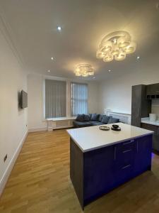 a large living room with a couch and a kitchen at Luxury Apartment APT5 in Wolverhampton