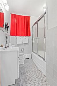 a bathroom with a toilet and a red shower curtain at Riviera Motel in Erie