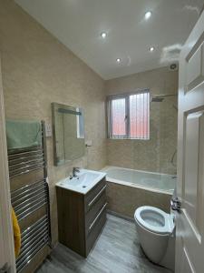 a bathroom with a sink and a toilet and a tub at Luxury Apartment APT5 in Wolverhampton