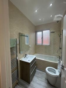 a bathroom with a sink and a tub and a toilet at Luxury Apartment APT5 in Wolverhampton