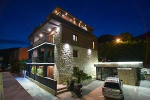 um edifício com um carro estacionado em frente em Misisuone Apartments Budva em Budva