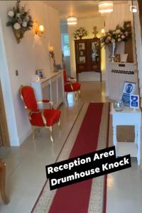 a living room with red chairs and a red rug at Drumhouse Guesthouse in Knock