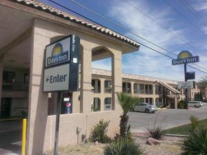 a sign in front of a building with a krispy kreme at Days Inn by Wyndham Kingman East in Kingman