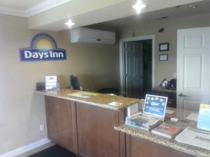 a day inn reception desk with a sign on the wall at Days Inn by Wyndham Kingman East in Kingman