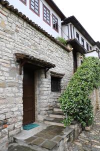 - un bâtiment en pierre avec des escaliers menant à une porte dans l'établissement Margarita Guest House, à Berat