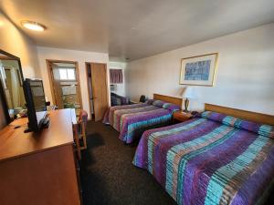 a hotel room with two beds and a flat screen tv at Riviera Motel in Erie