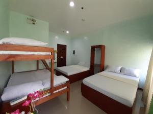 a room with two bunk beds and flowers in it at Westville Tourist Inn in Puerto Princesa City
