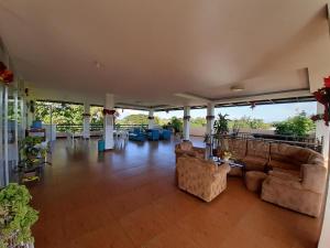 a large living room with couches and tables and chairs at Westville Tourist Inn in Puerto Princesa City