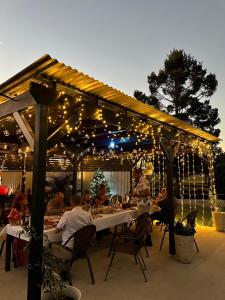 un grupo de personas sentadas en una mesa bajo una pérgola con luces en Sunflower Motel en Warialda