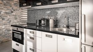 a kitchen with a sink and a tile wall at Apartment Orlando in Adeje