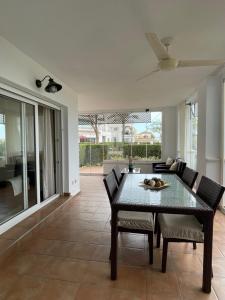 ein Esszimmer mit einem schwarzen Tisch und Stühlen in der Unterkunft APARTAMENTO DE LUJO EN PLANTA BAJA CON PISCINA EN LA TORRE GoLF RESORT in Roldán