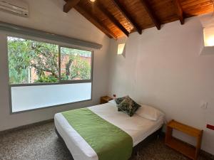 1 dormitorio con cama y ventana grande en Hotel Parador del Gitano, en Doradal