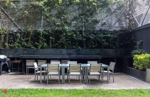 a table and chairs in a yard with a wall at Casa Magenta by Kukun in Mexico City +55 photos