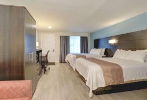 a hotel room with two beds and a desk at Quality Inn & Suites in Lincoln