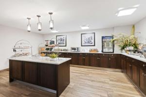 a large kitchen with wooden cabinets and a large island at Allentown Park Hotel, Ascend Hotel Collection in Allentown